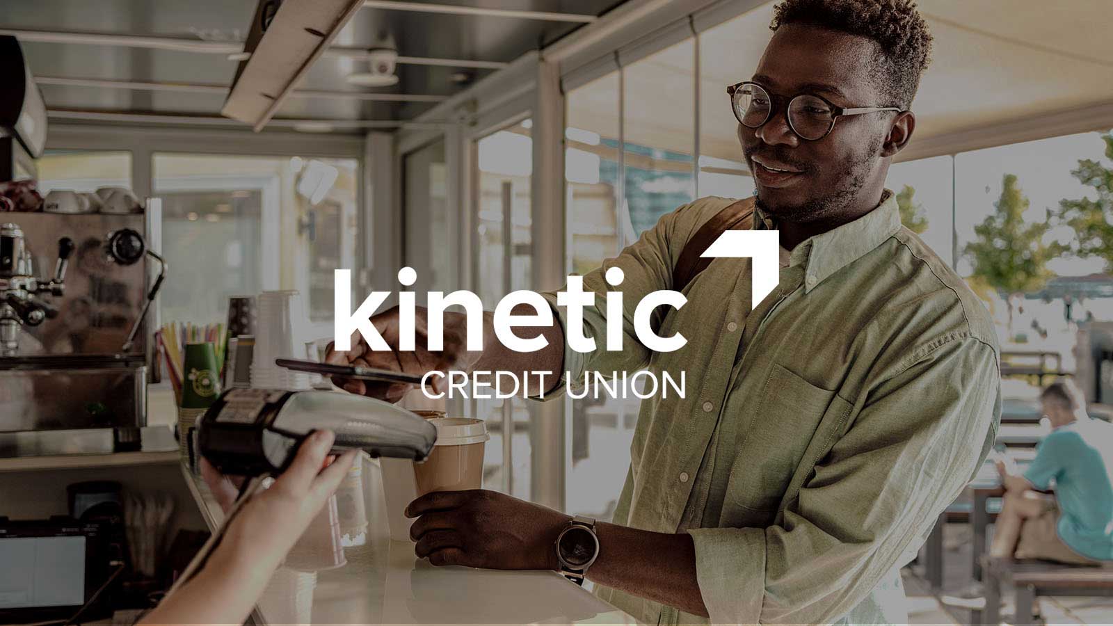Kinetic Credit Union logo overlay on a decorative image of a man paying with phone