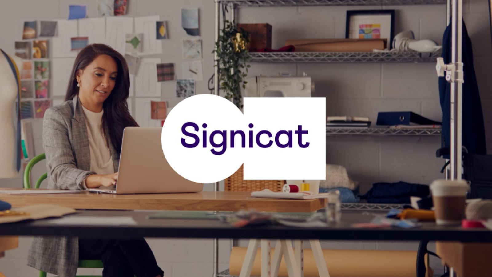 Signicat logo superimposed on image of woman working at table.