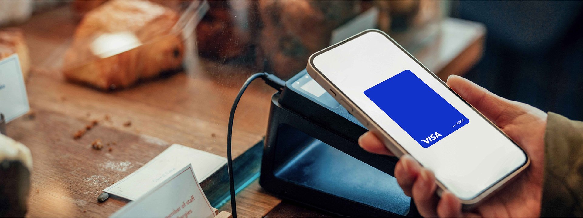 Mobile phone making a card payment at POS in cafe