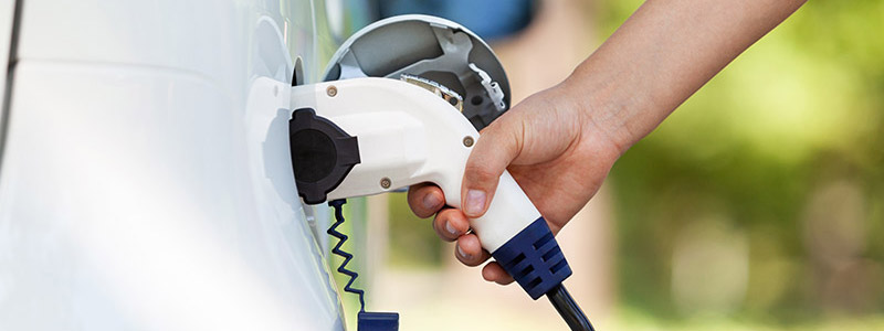 Close-up of person charging an electric car