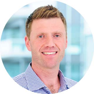 Portrait of Nick Mackie wearing a blue and white checkered shirt