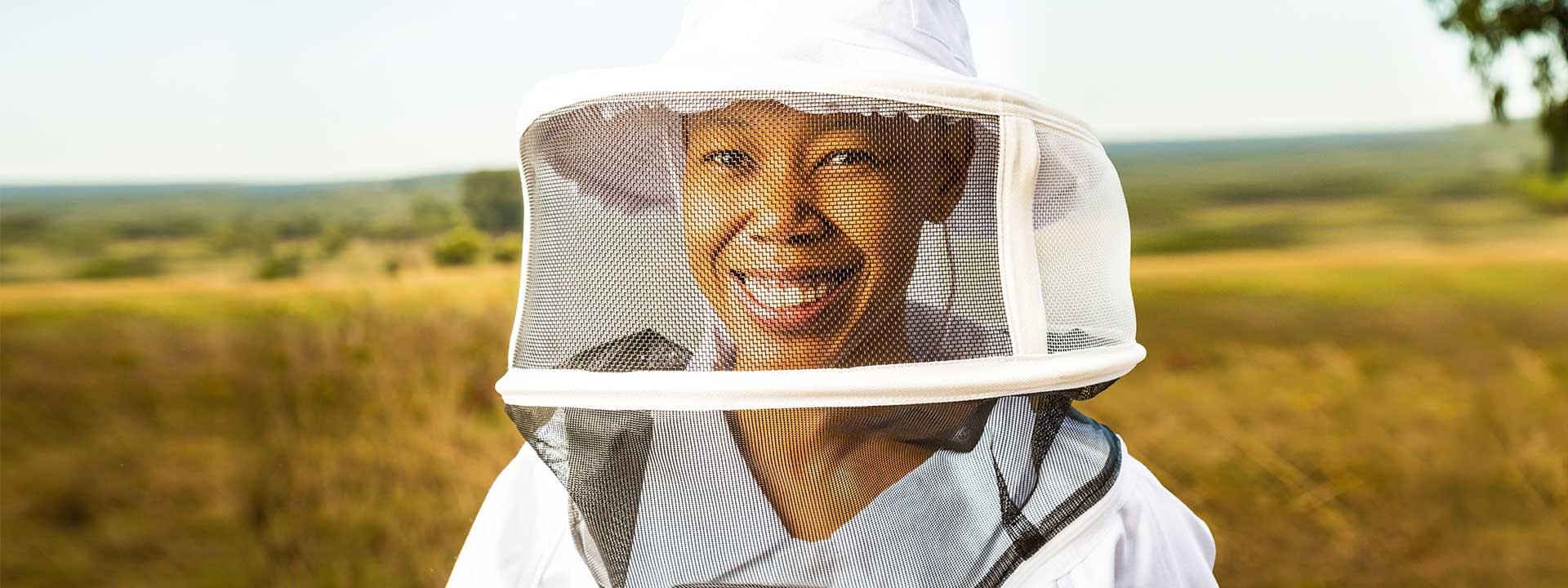 Mokgadi Mabela, founder of Native Nosi, wears a beekeeping suit and smiles while continuing her family’s beekeeping legacy.
