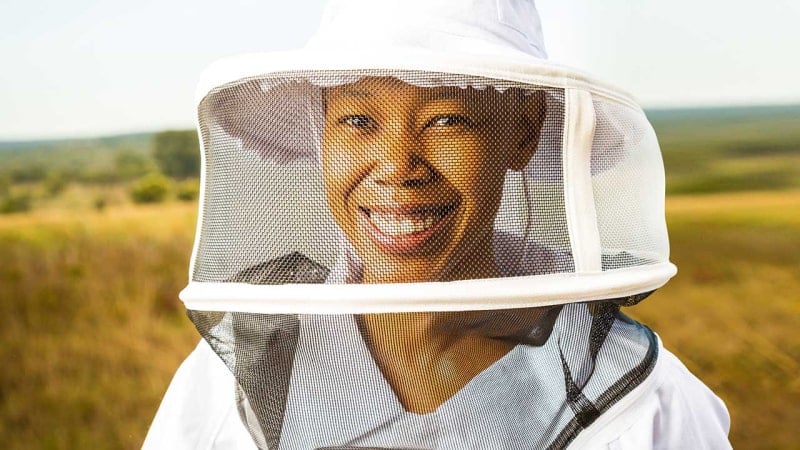 Mokgadi Mabela, founder of Native Nosi, wears a beekeeping suit and smiles while continuing her family’s beekeeping legacy.