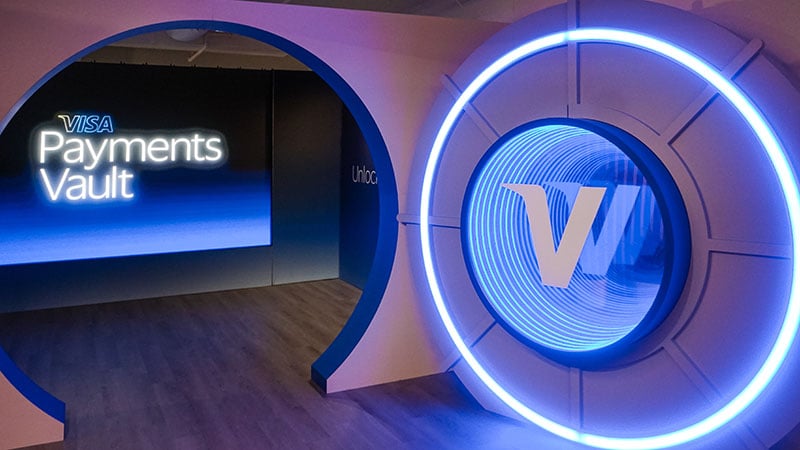 Event space with an open vault door with the Visa V and a screen displaying the words Visa Payments Vault