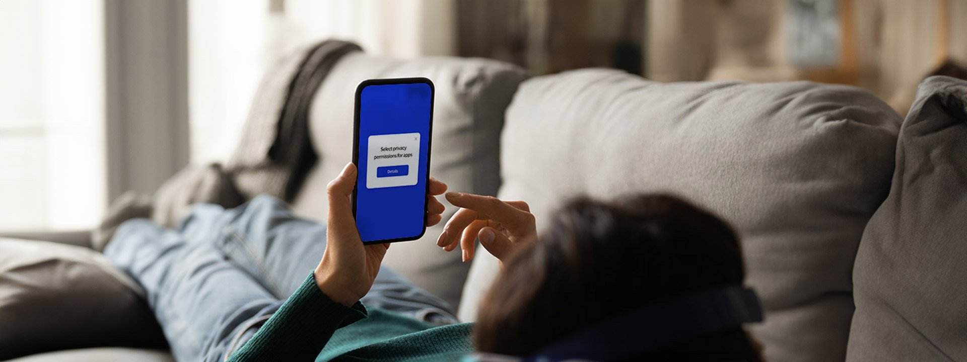 Person lying on couch looking at phone