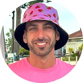 Portrait of business owner Jordan Levy wearing a pink shirt and strawberry bucket hat.