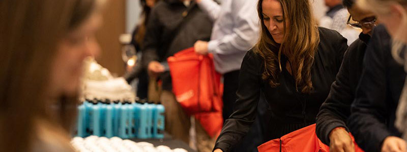 Visa's North America President, Kim Lawrence, puts hygiene products in a bag during a Red Cross kit building event.