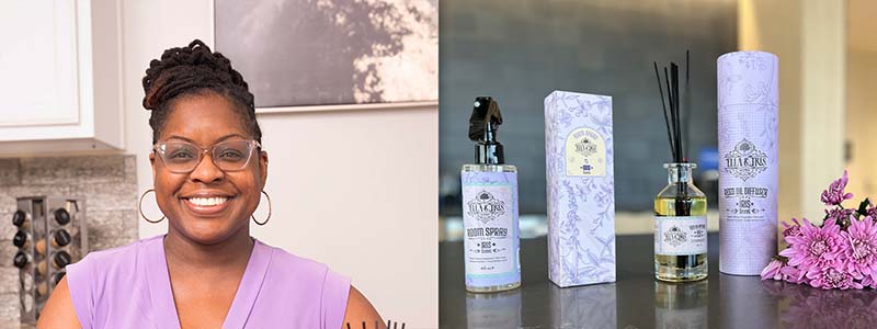 On left Felicia Johnson sits behind a line of products, on right room scent products sit on a table next to flowers.