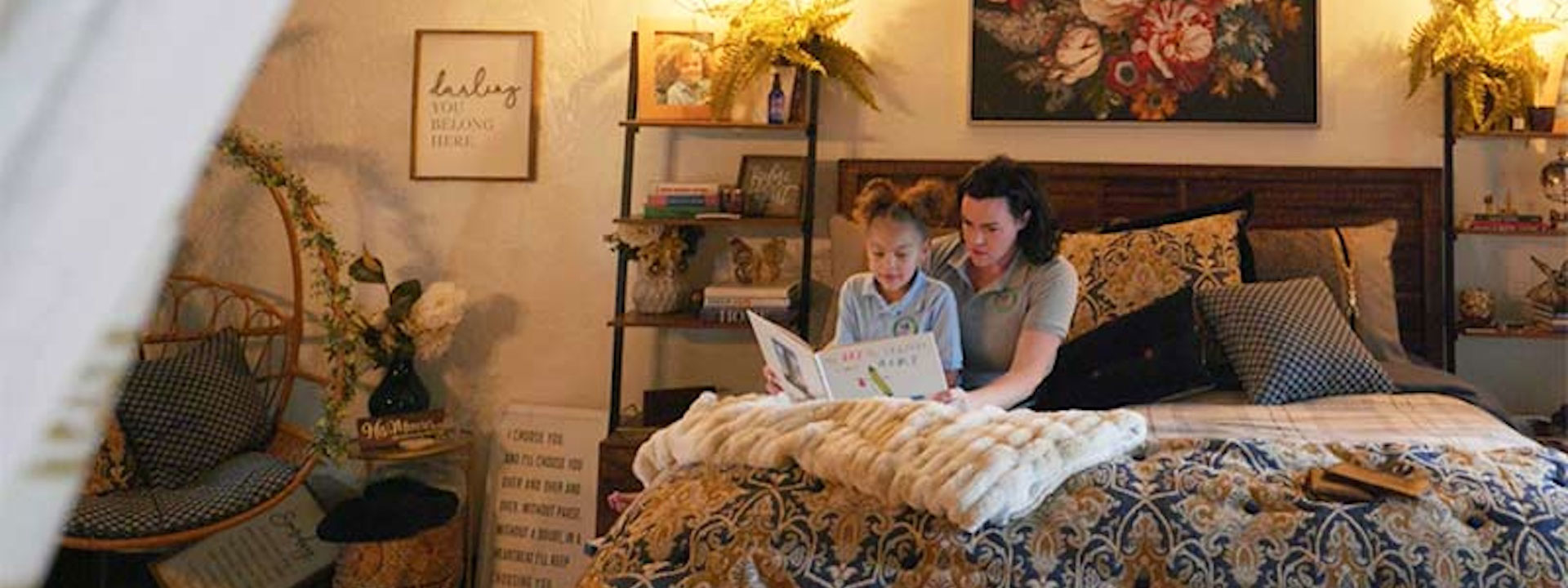 Mother reading to a book to her daughter in bed.