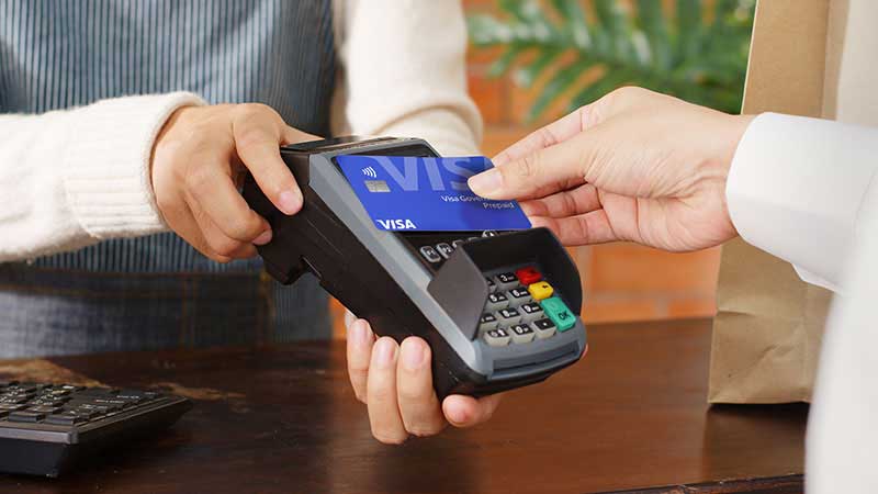 hand close up of contectless payment with POS terminal