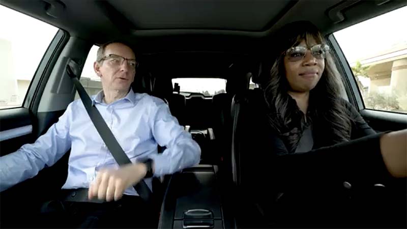 Woman driving a car with a man sitting in the passengers seat.