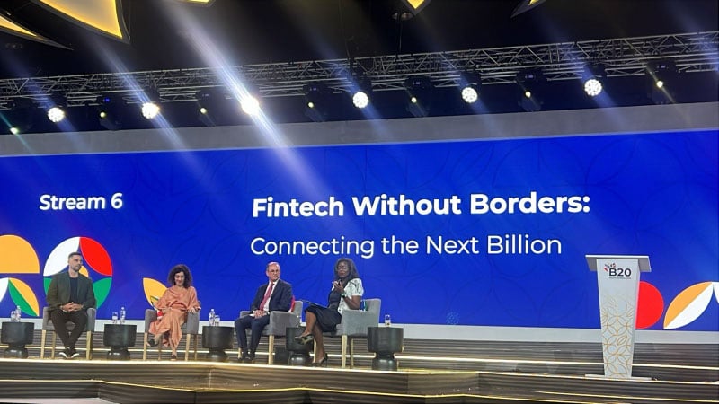 Panel discussion on fintech with four diverse speakers on stage. A large screen behind them reads "Fintech Without Borders: Connecting the Next Billion."