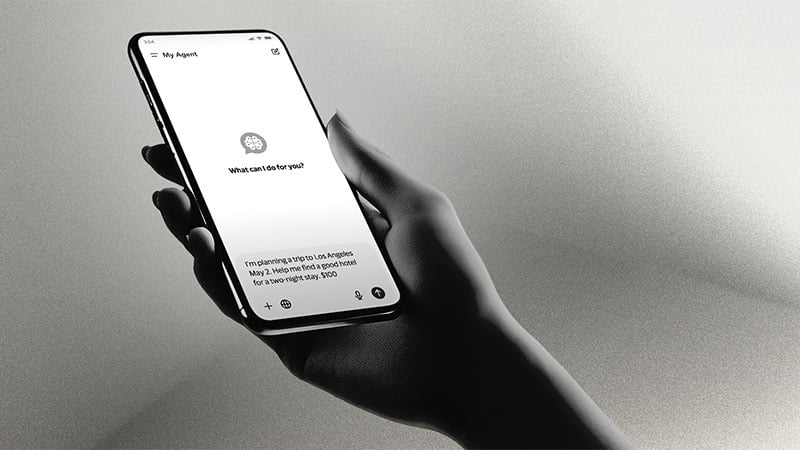 Silhouette hand holding a phone with Visa AI agent interface on the screen