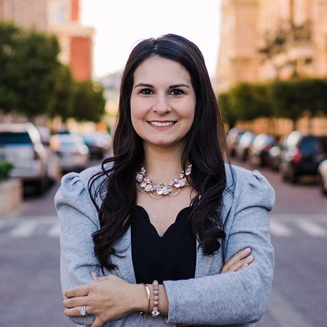 Entrepreneur Monica Fullerton smiling at camera with city street in background.