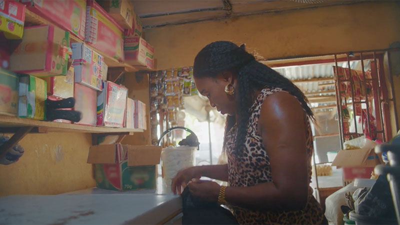 A woman standing in a local shop with boxed goods