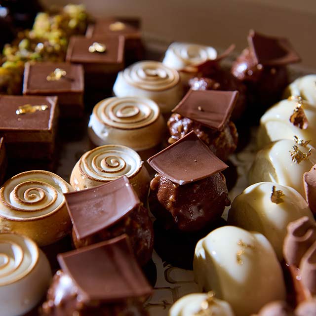 Close up assortment of gourmet chocolates on display at a bakery