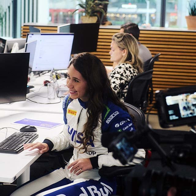 Driver Rafaela Ferreira sitting at a desk in an office building.
